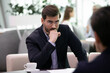 © fizkes - Serious young businessman talk with applicant or candidate at job interview feel suspicious doubtful at meeting. Concerned male boss or employer frustrated unsure about client or partner at briefing.