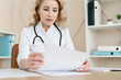 © brizmaker - Woman doctor working with document in clinic