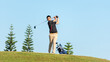 © freebird7977 - Golfer asia man approach on tee off for swing and hitting golf ball on slope green and looking fairway in course. Hobby playing game golf in holiday