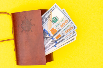 Business success concept. Saving money concept. Dollars in a brown wallet on a bright yellow trending background