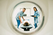 © My Ocean studio - Professional Doctor Radiologist In Medical Laboratory Controls magnetic resonance imaging or computed tomography or PET Scan with Female Patient Undergoing Procedure.