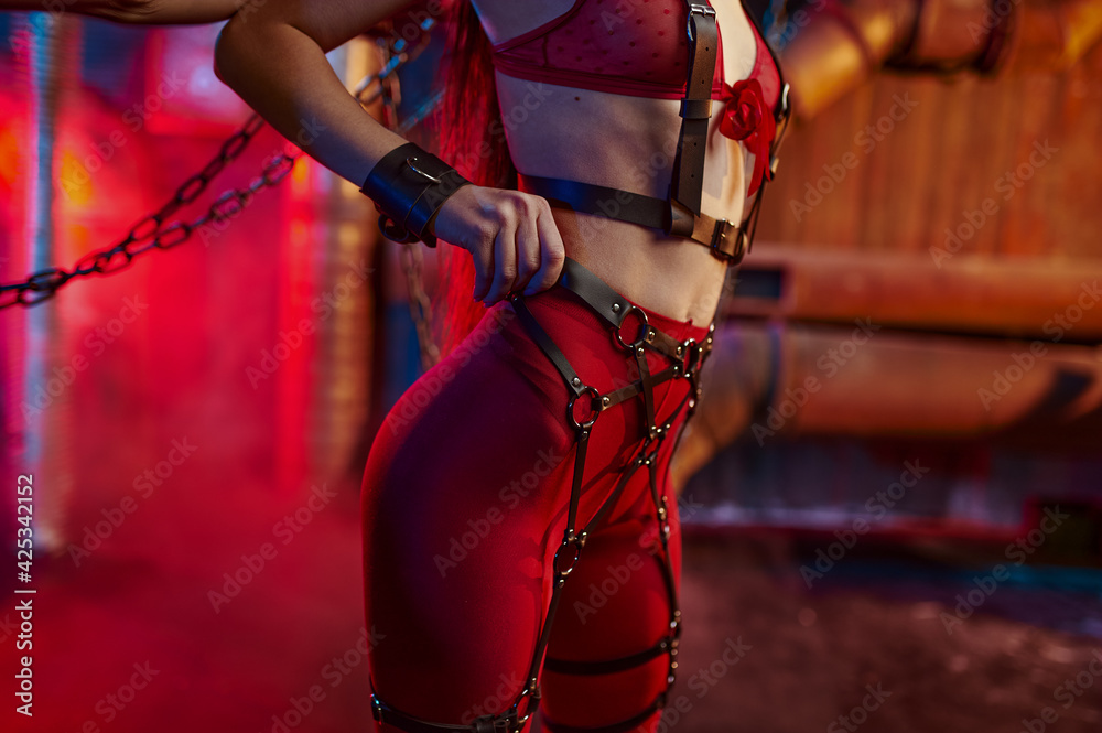 Sexy woman body in red bdsm suit chained up - obrazy, fototapety, plakaty 