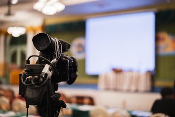 Wall Mural - Video camera taking live video streaming with people working background at meeting room. Selective focus.