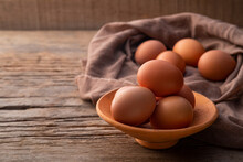 Chicken Eggs In Clay Bowl On Old Wood Table Background