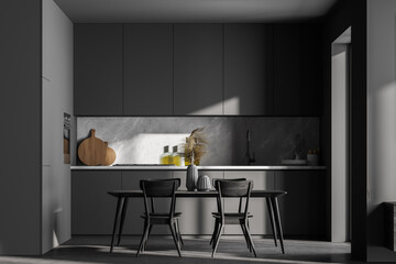 Dark cozy kitchen room interior with dining table and chairs