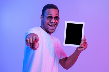 Wall Mural - African Guy Holding Digital Tablet With Black Screen And Pointing At Camera