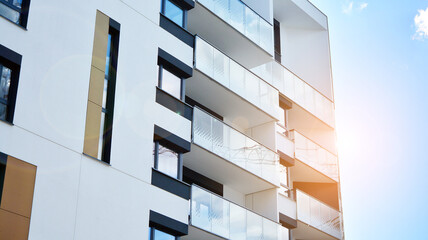 Facade of a modern apartment building. Glass surface with sunlight. Modern apartment buildings on a sunny day with a blue sky.