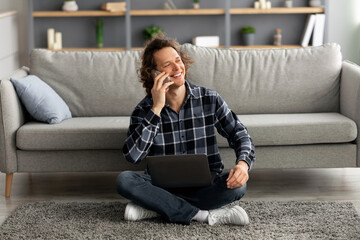 Poster - Guy Talking On Smartphone Sitting With Laptop On Floor Indoor