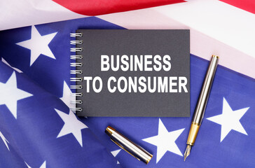 On the table is an American flag, a pen and a notebook with the inscription - BUSINESS TO CONSUMER