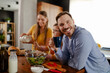 © Nebojsa - Portrait of the handsome dad while is drinking a coffee in the kitchen with his family in background
