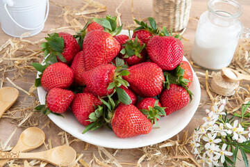 Wall Mural - Close-up of fresh, ripe, red strawberries on a plate on a table