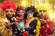 © Studio Romantic - People dressed in boas, party glasses and curly Afro wigs celebrating happy event at disco night club and blowing a kiss with shiny sparkling golden confetti to share positive festive mood with you