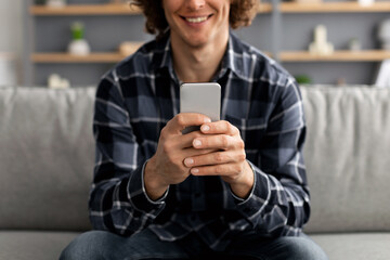 Poster - Unrecognizable Guy Using Mobile Phone Sitting On Sofa Indoor, Cropped