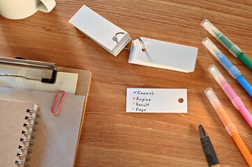 Leinwandbilder - There is a a word card with Search Engine Result Page written on it. They are on the desk along with stationery such as notebooks and colored pens.