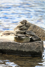 A Cairn Stack On A Large Flat Rock Near Water