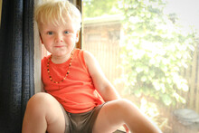Beautiful Little 2 Year Old Boy Sitting In Window Wearing Amber Bead Necklace