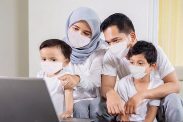 Sticker - Muslim family in face mask using a laptop at home