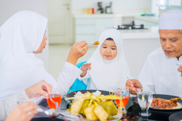 Wall Mural - Muslim little girl having feed by her grandmother