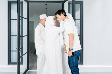 Wall Mural - Parents kissing their children during Eid Mubarak