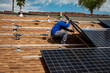 © F Armstrong Photo - Workers installing solar panels on a tile roofon a sunny day
