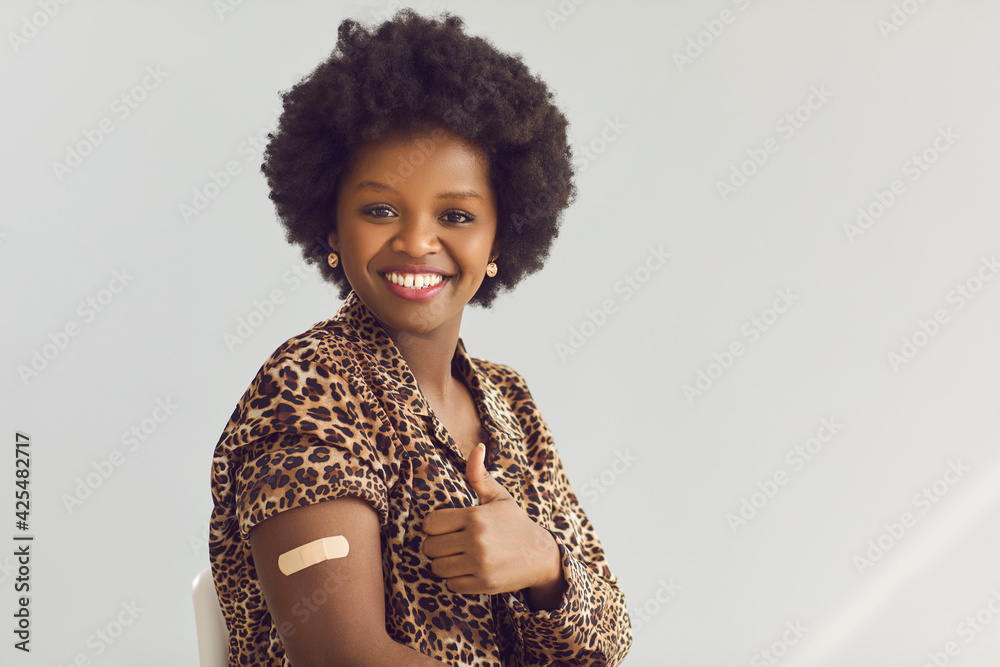 I'm okay. Portrait of happy female patient giving thumbs-up and showing arm with adhesive patch after getting Covid-19 vaccine. Vaccination, coronavirus immunity, safe travel concept. Space for text - obrazy, fototapety, plakaty 