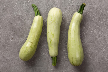 Wall Mural - Fresh zucchini on a gray concrete background.