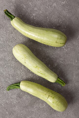 Wall Mural - Fresh zucchini on a gray concrete background.