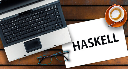 Poster - Haskell programming language. Word Haskell on paper and laptop on desk