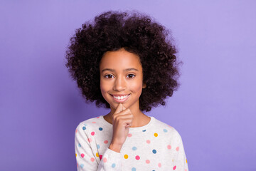 Photo portrait of thoughtful little girl touching chin in dotted shirt isolated on pastel violet color background