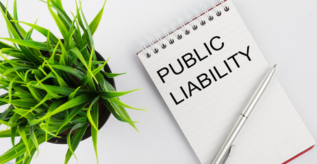Poster - Keyword PUBLIC LIABILITY - business concept text on a white notebook and pen, green flowers