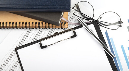 Poster - Office desk table with notebooks, supplies,analysis chart, on white background. Top view with copy space