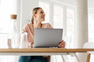 Happy smiling young businesswoman looking aside in a low angle view