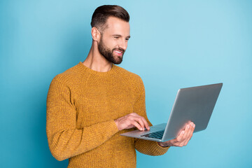 Sticker - Portrait of nice attractive focused cheerful guy employee using laptop programming isolated over bright blue color background