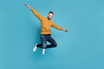 Sticker - Full length body size view of attractive cheerful guy jumping having fun like plane isolated on bright blue color background