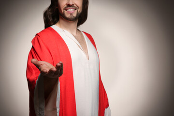 Poster - Jesus Christ reaching out his hand on beige background, closeup. Space for text