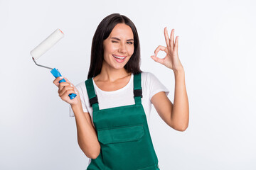 Sticker - Photo of flirty lady hold painter roller show okey wink eye wear green overall isolated white color background