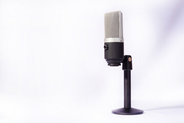 professional condenser microphone on a pedestal isolated with white background, selective focus.