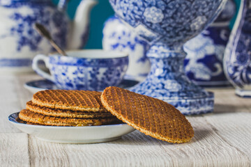 Wall Mural - Close-up traditional Dutch sweet and crispy stroopwafels over blue Dutch tableware.