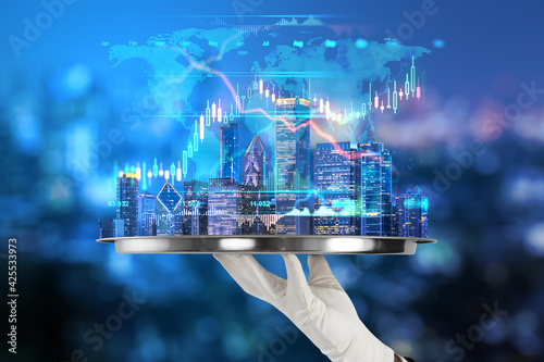 Obraz Dibond Development and real estate concept with metallic tray in hand with digital growing forex chart graph and world map on night city background
