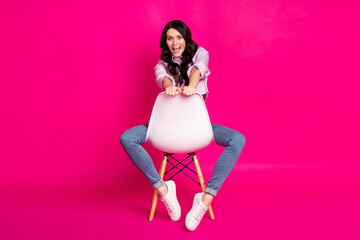 Poster - Full size photo of impressed brunette nice lady sit look empty space wear jacket jeans sneakers isolated on pink background