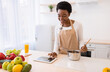 © Prostock-studio - African Housewife Using Tablet Cooking And Browsing Recipes In Kitchen