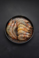 Raw pacific white prawns on dark background. Fresh seafood concept.