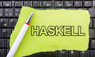 Poster - Haskell programming language. Word Haskell on paper and laptop