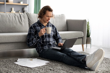 Poster - Guy Using Laptop Working Online Drinking Coffee Sitting At Home