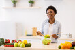 © Prostock-studio - Cheerful Black Female Housewife Cooking Fresh Vegetable Salad In Kitchen