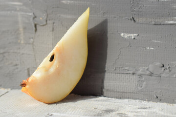 a slice of yellow juicy pear.hard shadow