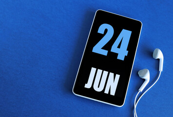 June 24. 24 st day of the month, calendar date. Smartphone and white headphones on a blue background. Place for your text. Springtime month, day of the year concept