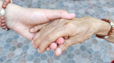 Young hand holding old hand women, Concept for the elderly care.