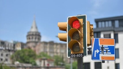 Wall Mural - Traffic light on crossroad in action in Istanbul against the a Galata Tower. Photo sequence.