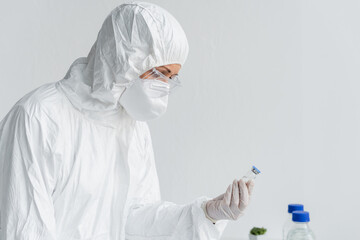 Wall Mural - Scientist in hazmat suit holding vaccine in laboratory